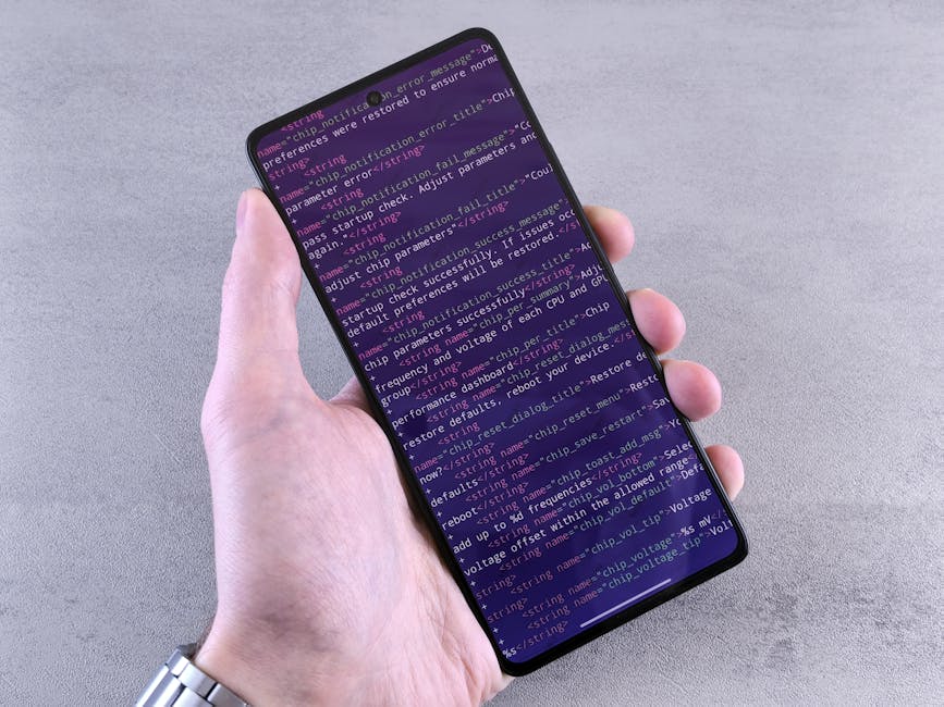 Close-up of a smartphone displaying code text held in a person's hand.