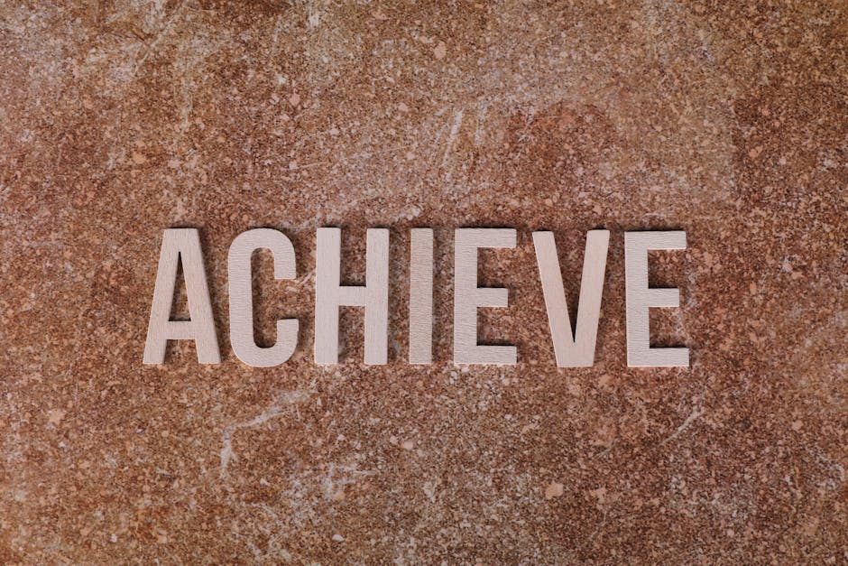 Wooden letters spelling 'ACHIEVE' on a textured brown surface, conveying motivation and success.